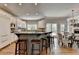 Open-concept kitchen with an island, stainless steel appliances, custom cabinets, and adjacent dining area at 9770 Rod Rd, Alpharetta, GA 30022