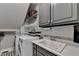 Functional laundry room features a utility sink, storage cabinets, modern washer and dryer, and extra shelving at 9770 Rod Rd, Alpharetta, GA 30022