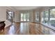 Bright living room with hardwood floors, large windows offering scenic views, and staircase access at 9770 Rod Rd, Alpharetta, GA 30022