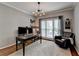 Well-lit home office includes a desk, leather chair, and large window, perfect for remote work at 9770 Rod Rd, Alpharetta, GA 30022