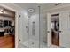 Modern tiled shower with glass enclosure, situated between a bedroom and closet at 9770 Rod Rd, Alpharetta, GA 30022