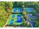 Multiple tennis courts with pristine blue surfaces surrounded by lush trees offer a vibrant recreational space at 9770 Rod Rd, Alpharetta, GA 30022