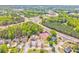 Community aerial view showing a pool, tennis court, and surrounding houses with lush green trees at 1302 Gardenia Ct, Villa Rica, GA 30180