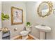 Charming powder room features a pedestal sink, and an ornate gold-framed mirror at 1302 Gardenia Ct, Villa Rica, GA 30180