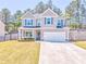 Beautiful home featuring a well-kept lawn, tidy landscaping and gray siding with complementary shutters at 1302 Gardenia Ct, Villa Rica, GA 30180
