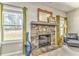 Cozy fireplace with a stone facade, decorative mirror, and large windows at 1302 Gardenia Ct, Villa Rica, GA 30180