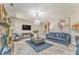 Stylish living room with plush blue sofa, stone fireplace, and modern chandelier at 1302 Gardenia Ct, Villa Rica, GA 30180