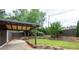 This grassy backyard includes a covered parking area with stone accents along the perimeter at 2356 Pinkney Dr, Marietta, GA 30062