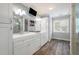 Bright bathroom features dual sinks, white cabinetry, wood floors, and a wall-mounted TV at 2356 Pinkney Dr, Marietta, GA 30062