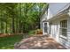Brick patio with grill, surrounded by large grassy backyard and trees at 1000 N Harbor Ct, Atlanta, GA 30328