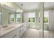 Bright bathroom featuring a double vanity, carpet, mirrors, and natural light from the window at 1000 N Harbor Ct, Atlanta, GA 30328