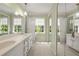 Bright bathroom featuring a double vanity, carpet, mirrors, and natural light from the window at 1000 N Harbor Ct, Atlanta, GA 30328