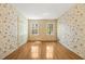 Bedroom featuring hardwood floors, natural light from two windows, and charming floral wallpaper at 1000 N Harbor Ct, Atlanta, GA 30328