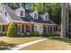 Charming brick home features blue shutters, dormer windows, a lush lawn, and mature trees at 1000 N Harbor Ct, Atlanta, GA 30328