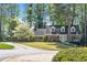 Charming two-story brick home with blue shutters and a lush front yard featuring a beautiful blossoming tree at 1000 N Harbor Ct, Atlanta, GA 30328