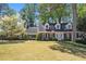 Charming two-story brick home with blue shutters and a lush front yard featuring a beautiful blossoming tree at 1000 N Harbor Ct, Atlanta, GA 30328