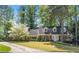 Charming two-story brick home with blue shutters and a lush front yard featuring a beautiful blossoming tree at 1000 N Harbor Ct, Atlanta, GA 30328