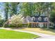 Charming two-story brick home with blue shutters and a lush front yard featuring a beautiful blossoming tree at 1000 N Harbor Ct, Atlanta, GA 30328