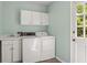 Bright laundry room with washer, dryer, sink, and cabinets; access to outdoors at 1000 N Harbor Ct, Atlanta, GA 30328