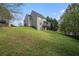 View of the house's backyard showing a gentle slope, screened-in porch, and a side entrance at 105 Blackberry Ct, Woodstock, GA 30188