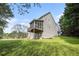 Expansive backyard featuring a screened porch, lush lawn, and mature trees under a bright, sunny sky at 105 Blackberry Ct, Woodstock, GA 30188