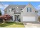 Charming two-story home with gray brick, shutters, landscaped yard, and a two-car garage at 105 Blackberry Ct, Woodstock, GA 30188