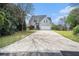 View of a two-story gray home with a large driveway surrounded by beautiful green lawn and mature trees at 105 Blackberry Ct, Woodstock, GA 30188