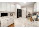View of a kitchen featuring white cabinetry, granite counters, black appliances, and hardwood flooring at 105 Blackberry Ct, Woodstock, GA 30188