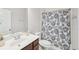 Well-lit bathroom featuring a shower with a decorative curtain, a toilet, and vanity with a large mirror at 1401 Kings Park Nw Dr, Kennesaw, GA 30152
