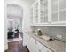 Elegant butler's pantry with granite countertops, glass-front cabinets, and hardwood floors leading into the dining room at 1401 Kings Park Nw Dr, Kennesaw, GA 30152