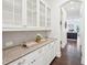 Elegant butler's pantry with granite countertops, glass-front cabinets, and hardwood floors, perfect for serving and storage at 1401 Kings Park Nw Dr, Kennesaw, GA 30152