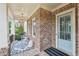 Welcoming front porch with brick columns, outdoor seating, and stylish decor at 1401 Kings Park Nw Dr, Kennesaw, GA 30152