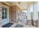 Inviting front porch with brick columns, comfortable seating, and decorative lanterns at 1401 Kings Park Nw Dr, Kennesaw, GA 30152