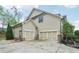 Three car garage with tan siding and brick accents at 1401 Kings Park Nw Dr, Kennesaw, GA 30152