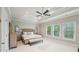 Spacious main bedroom featuring a tray ceiling, ceiling fan, and abundant natural light from large windows at 1401 Kings Park Nw Dr, Kennesaw, GA 30152