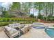Outdoor seating area with stone patio, lounge furniture, large umbrella, and pool in background at 1401 Kings Park Nw Dr, Kennesaw, GA 30152