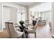 Formal dining area featuring a glass-topped table and modern chandelier, flowing into a bright kitchen with island seating at 4356 Jenkins Ne Dr, Roswell, GA 30075