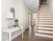 Inviting entryway with hardwood floors, a white console table, and a staircase leading to the upper level of the home at 4356 Jenkins Ne Dr, Roswell, GA 30075