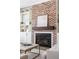 Close-up view of the living room's brick fireplace, showcasing the mantle, artwork, and built-in shelving details at 4356 Jenkins Ne Dr, Roswell, GA 30075