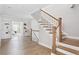 Bright hallway with hardwood floors and staircase with white and wood banisters at 4356 Jenkins Ne Dr, Roswell, GA 30075