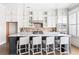 Bright, open kitchen with white cabinetry, brick backsplash, quartz countertops, and a large island with seating at 4356 Jenkins Ne Dr, Roswell, GA 30075