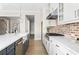 Modern kitchen featuring custom cabinets, white countertops, stainless steel appliances, and a farmhouse sink at 4356 Jenkins Ne Dr, Roswell, GA 30075