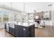 Open-concept kitchen and living room area, featuring a center island, brick fireplace, and built-in bookshelves at 4356 Jenkins Ne Dr, Roswell, GA 30075