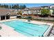Community pool surrounded by ample seating, mature trees, and townhome residences at 4356 Jenkins Ne Dr, Roswell, GA 30075