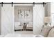Cozy sitting area adjacent to the main bedroom featuring barn doors, light gray walls, and neutral decor at 4356 Jenkins Ne Dr, Roswell, GA 30075