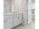 Bathroom with double sink vanity, white cabinets and modern fixtures plus an open door and natural light at 631 Skytop Dr, Cumming, GA 30040
