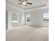 Spacious bedroom featuring neutral carpeting, two windows, a ceiling fan, and an en suite bathroom with a tub at 631 Skytop Dr, Cumming, GA 30040