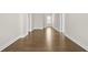 Hallway with wood flooring and white trim, leading to multiple rooms with natural light at 631 Skytop Dr, Cumming, GA 30040