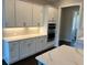 Modern kitchen featuring white cabinets, stainless steel appliances, and quartz countertops at 631 Skytop Dr, Cumming, GA 30040