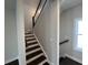 A modern staircase with wooden stairs and black metal railings at 631 Skytop Dr, Cumming, GA 30040